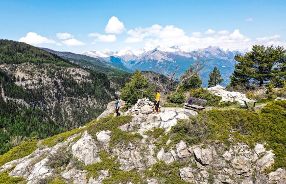 Deux personnes sur le rocher du Château à Vars, avec les Ecrins en arrière plan