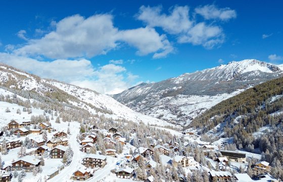 Vue élargie de chalets à Vars. Neige et ciel bleu