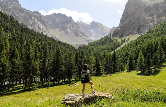 Vue sur la Font Sancte dans le val d'Escreins. Une personne de dos au milieu, au premier plan.
