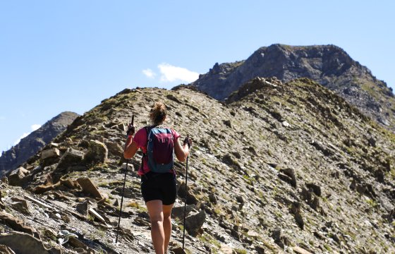 Randonneuse de dos marchant sur une crête minérale