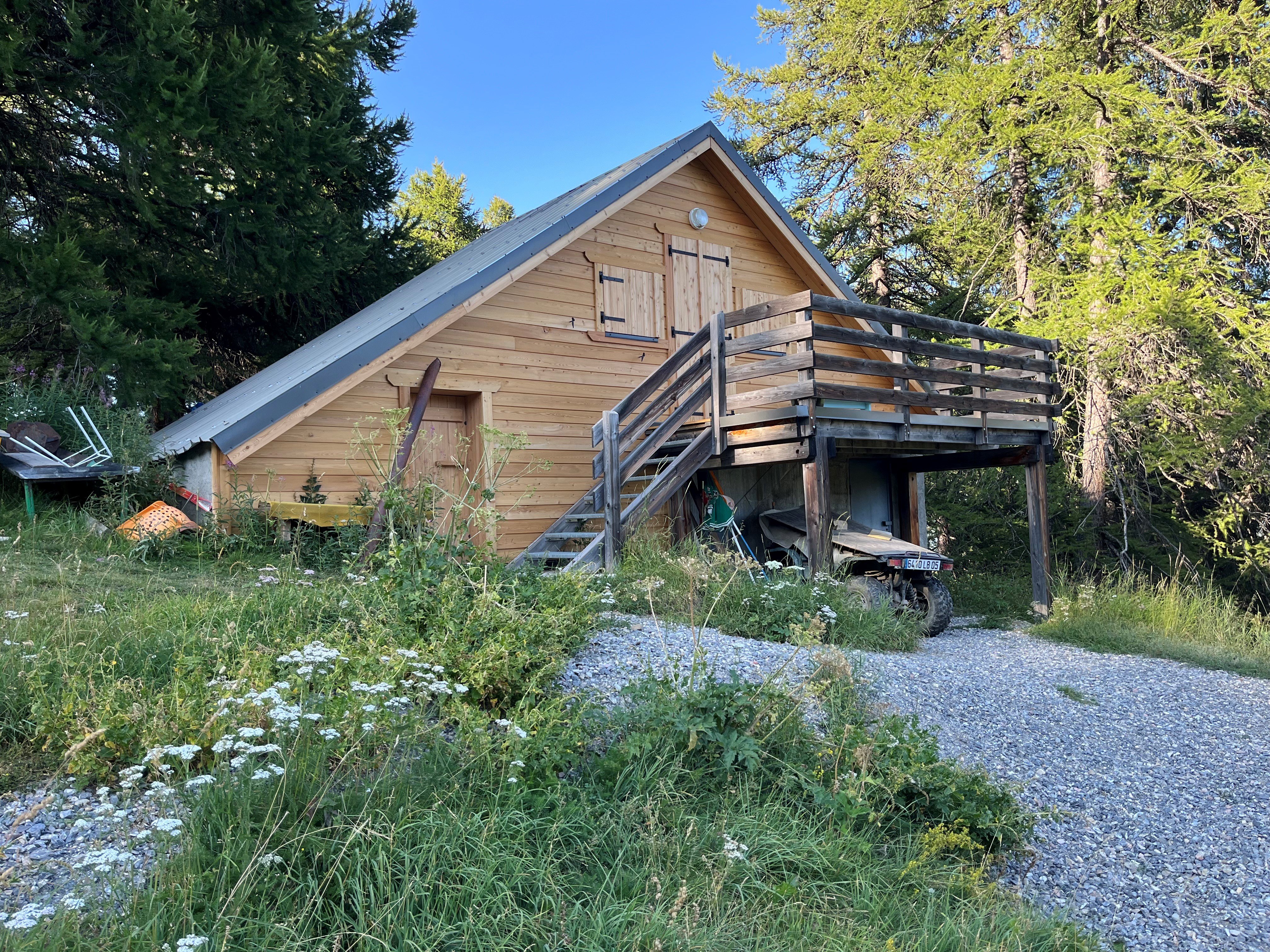 vue extérieure de la façade de la cabane de Peyrol située à Vars; bardage bois; escalier extérieur; végétation aux alentours