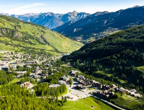 vue aérienne du villages des Claux avec la sortie amont en premier plan et le fond de vallée et montagnes en arrières plan